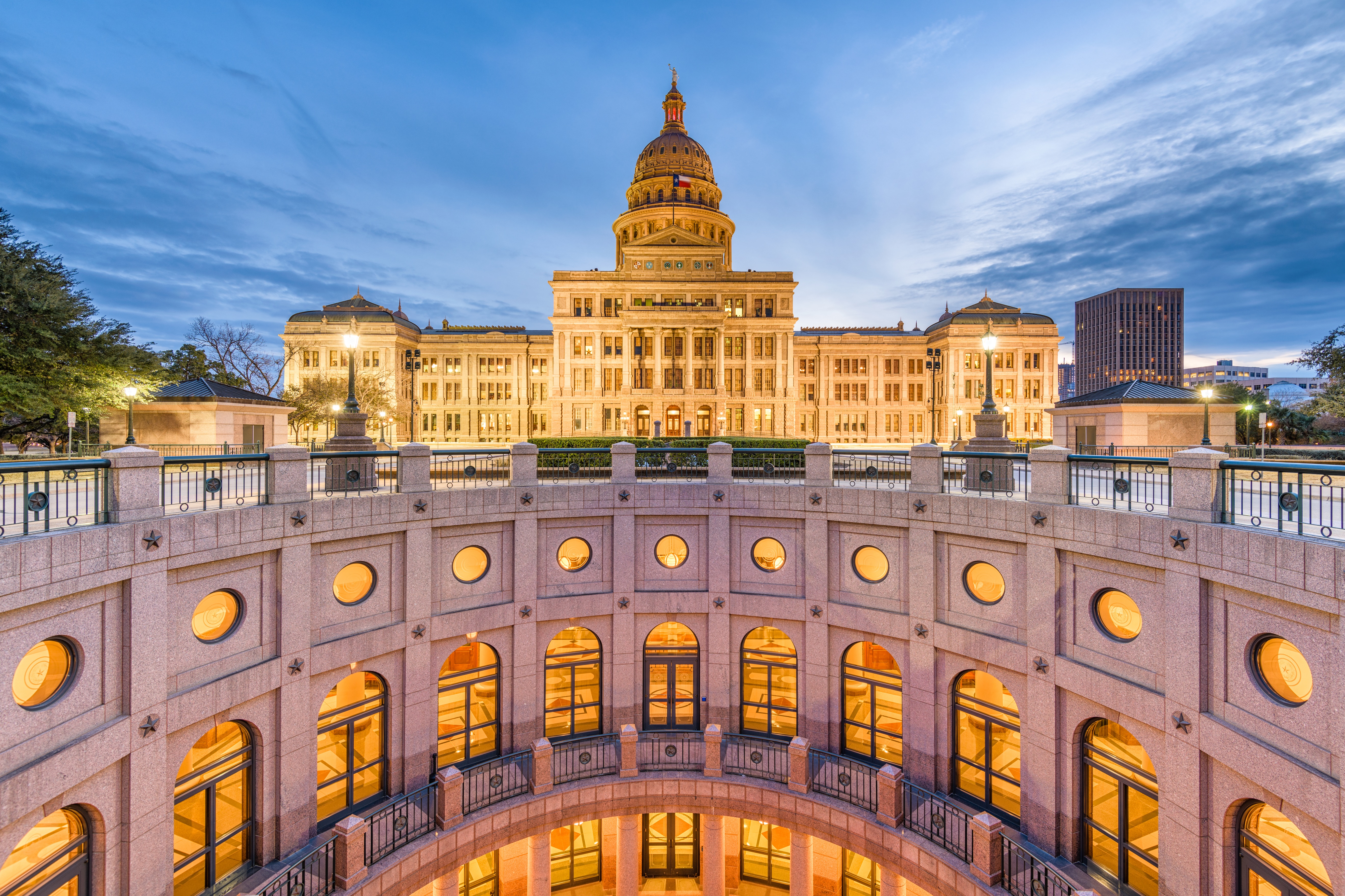 Texas State Capitol in Austin at dusk with the landscaped rotunda in the foreground.