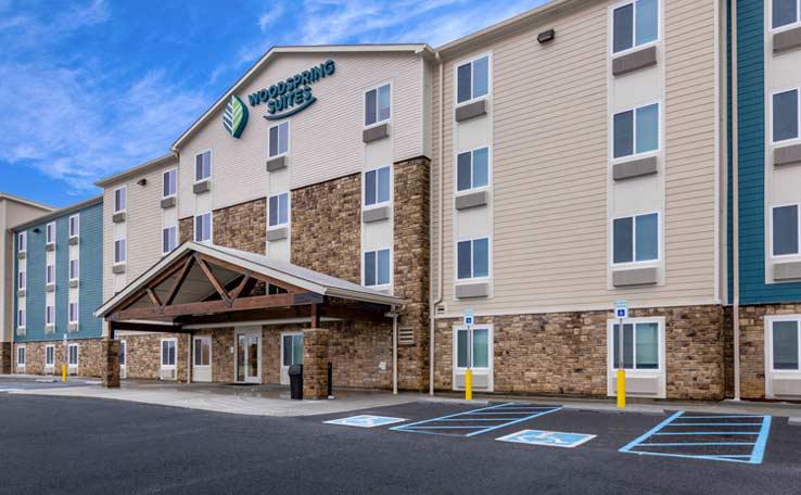 WOODSPRING SUITES INDAS EXTENDED STAY HOTEL EXTERIOR DAY 1 738X456~800 